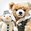 Close-up of Steiff Christmas bear in winter scarf with snowman companion, made from finest mohair